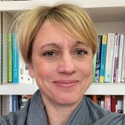 Claudine Bowyer-Crane smiling in front of a book case